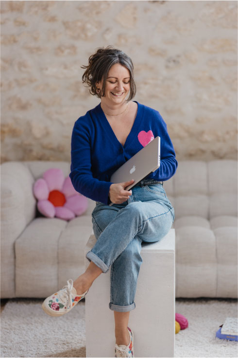 Steffi, assise sur un tabouret les jambes croisées, ouvre son ordinateur