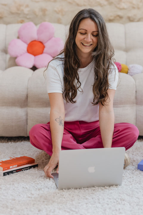 Steffi, assise par terre, travaille sur son ordinateur