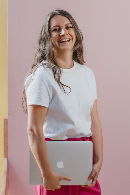 Steffi Lala, webdesigner à Montpellier, sourit en tenant son ordinateur dans les mains